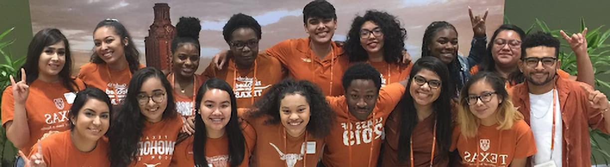 Smiling group of UT students wearing burnt orange shirts